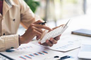 Close up hand of stress young asian businessman,male is pressing a calculator to calculate tax income and expenses, bills, credit card for payment or payday at home, office.Financial, finance concept. photo