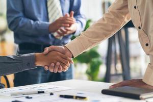 Real estate broker agent and customer shaking hands after signing contract documents for realty purchase, Bank employees congratulate, Concept mortgage loan approval. photo