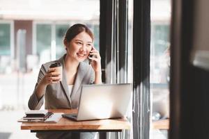 mujer joven con tarjeta de crédito y usando computadora portátil. empresaria trabajando en casa. compras en línea, comercio electrónico, banca por Internet, gastar dinero, trabajar desde el concepto de hogar foto