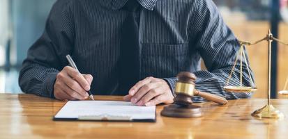 Business and lawyers discussing contract papers with brass scale on desk in office. Law, legal services, advice, justice and law concept. photo