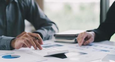 Close-up of Businessman hands pointing at turnover graph while discussing it on wooden desk with pen in meeting room, Business financial working concept, business people pointing at business document, photo