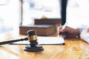 Business and lawyers discussing contract papers with brass scale on desk in office. Law, legal services, advice, justice and law concept. photo