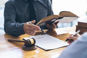 Business people negotiating a contract. Human hands working with documents at desk and signing contract, lawyer concept. photo