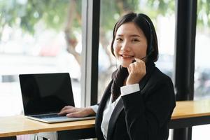 joven empresaria con auriculares y portátil en una videollamada. foto