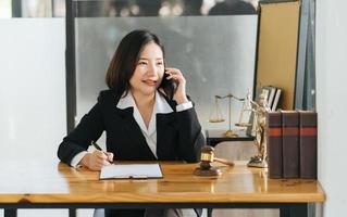 Midsection Of Lawyer Working At Desk In Courtroom, talking on a mobilephone with client. photo