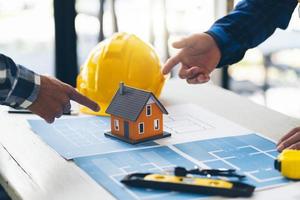 Architect and engineer meeting Planning for a New Project with construction equipment on table, Architect and engineer working with blueprint. photo