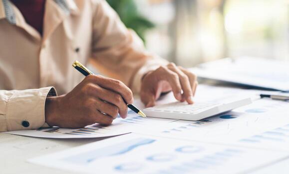 mujeres de negocios que usan computadora y calculadora durante la nota algunos datos en el bloc de notas para calcular las finanzas en la oficina en casa. foto