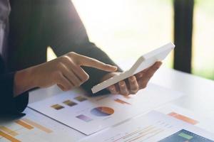 Businesswoman hand pen pointing on business document at meeting discussion and analysis data the charts and graphs showing the results at meeting.Business financial and accounting concept. photo