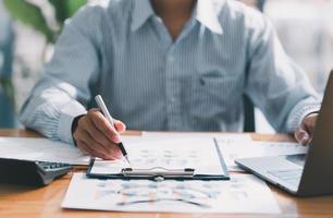 Financial businessman calculating corporate income tax data And analyzing charts of financial stocks that are in good condition with growth and progress, Investment in finance and accounting. photo