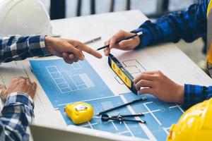 Engineer and Architect meeting working and pointing at a drawings in office for discussing. Engineering tools and construction concept,Engineers and Architects Brainstorm. photo