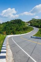 Curved asphalt road with sign curves in the mountains photo