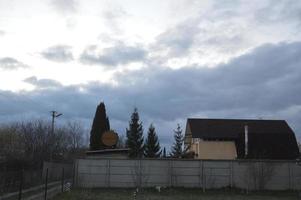 Thunderclouds in the evening on the sky in the village photo