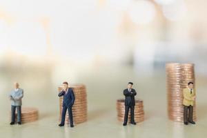 Business, Teamwork, Investment and Planning Concept.  Close up of group of businessman miniature people figure standing with stack of coins with copy space. photo