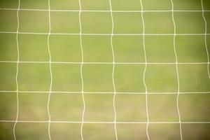 Close up of white football  soccer goal net with green grass as background using as sport wallpaper or background.