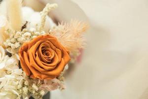 concepto de amor y día de san valentín. primer plano de ramo de flores de rosas naranjas marrones en blanco con espacio de copia. foto