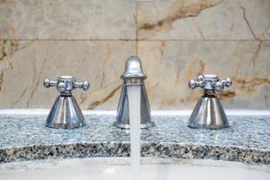 Close up the stainless faucet in the toilet. photo