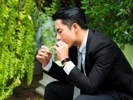 Young businessman smoking and thinking about business issues photo
