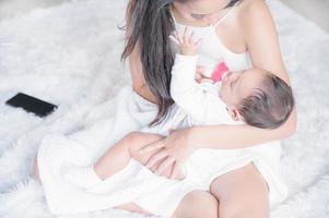 The little girl who was born recently is drinking milk and adapts to learn the things photo