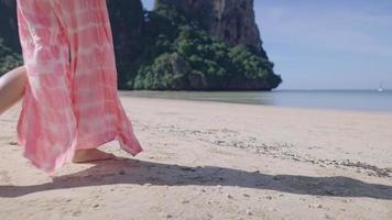 Close up on white slim female legs in long skirt which blown by the wind, strolling by the coast on vacation, amazing natural resources, tourist spending time on relaxing holiday, non urban scene video