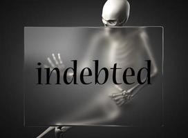 indebted word on glass and skeleton photo