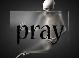 pray word on glass and skeleton photo