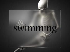 palabra de natación sobre vidrio y esqueleto foto