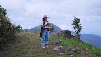 Female backpacker asks for directions from a male traveler walking past the top of the mountain. video