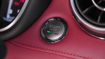 la main du conducteur appuie sur le bouton pour démarrer le moteur de la voiture. démarrage sans clé du moteur. concept de transport et de technologie video