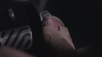 Close-up of feet on the accelerator pedal and brake pedal in a car. The driver drives the car by pressing the accelerator pedal of the car. inside vehicle. video