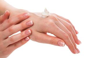 Woman applying moisturizer cream on hands photo