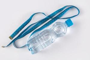 Bottle with water and measure tape photo