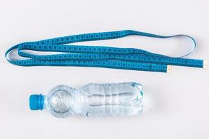 Bottle with water and measure tape photo