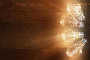 Glowing lightbulbs on wooden background photo