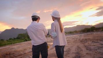 un père constructeur professionnel donnant une explication de travail à un jeune adulte hérite de sa fille sur son lieu de travail, hérite d'une entreprise familiale, du développement immobilier, porte un équipement de sécurité video