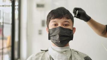 vue de face barbier asiatique utilisant des ciseaux à cheveux coupant les cheveux d'un client masculin asiatique, magasin de barbier, opportunité d'occupation, produit de soins de santé pour hommes, réouverture de la petite entreprise pandémique covid-19 video