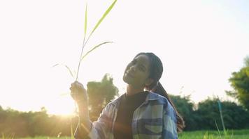 jovem agricultor asiático arranca as raízes das árvores de grama mostrando a vida rural da agricultura sustentável, cultivando plantas ao ar livre no verão, época de colheita para cultivo ao ar livre, conceito do dia da terra video