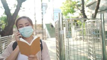 young attractive student with a small note talking on the phone in the university. Happy student after exam. New modern fully functional education facility. Concept of unlimited wireless education video