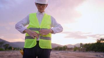 Closeup portrait of male civil engineer wearing safety vest and protective hardhat while standing on construction site, affordable life-saving garment, reducing accident case in workplace, equipment