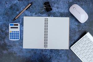 Laptop, smartphone, and supplies on a black office desk table. Computer tools on a desk table in the office, Top view with copy space, flat lay. photo