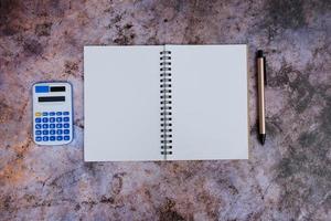 Laptop, smartphone, and supplies on a black office desk table. Computer tools on a desk table in the office, Top view with copy space, flat lay. photo