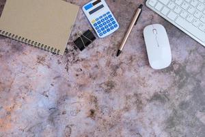 Blank notebook is in the middle of office desktable with pen and office supplies. Top view, flat lay. photo