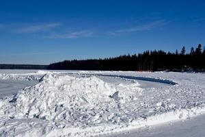 the snow covered shoreline of a frozen lake