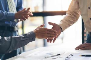 Closeup of male and female hands handshaking after effective negotiation showing mutual respect and intention for strong working relationships. Man in suit greeting female partner. Business concept photo