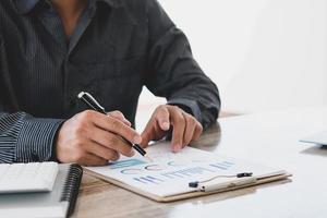 Close up view of bookkeeper or financial inspector hands making report, calculating or checking balance. Home finances, investment, economy, saving money or insurance concept. photo