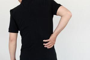 asian man with lumbar pain, backache and massage on waist to pain relief. photo