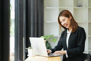 hermosa linda joven empresaria asiática en el café, usando computadora portátil. foto