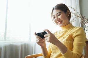 Asian woman excited while playing mobile games, reading good news while surfing the internet world. photo