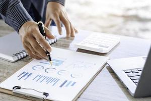 vista de cerca de las manos del tenedor de libros o del inspector financiero haciendo informes, calculando o comprobando el saldo. finanzas domésticas, inversión, economía, ahorro de dinero o concepto de seguro. foto