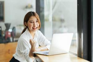 Beautiful cute asian young businesswoman in the cafe, using computer laptop. photo