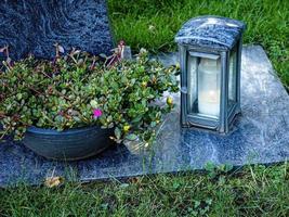 Grave decoration with candle and flowers photo
